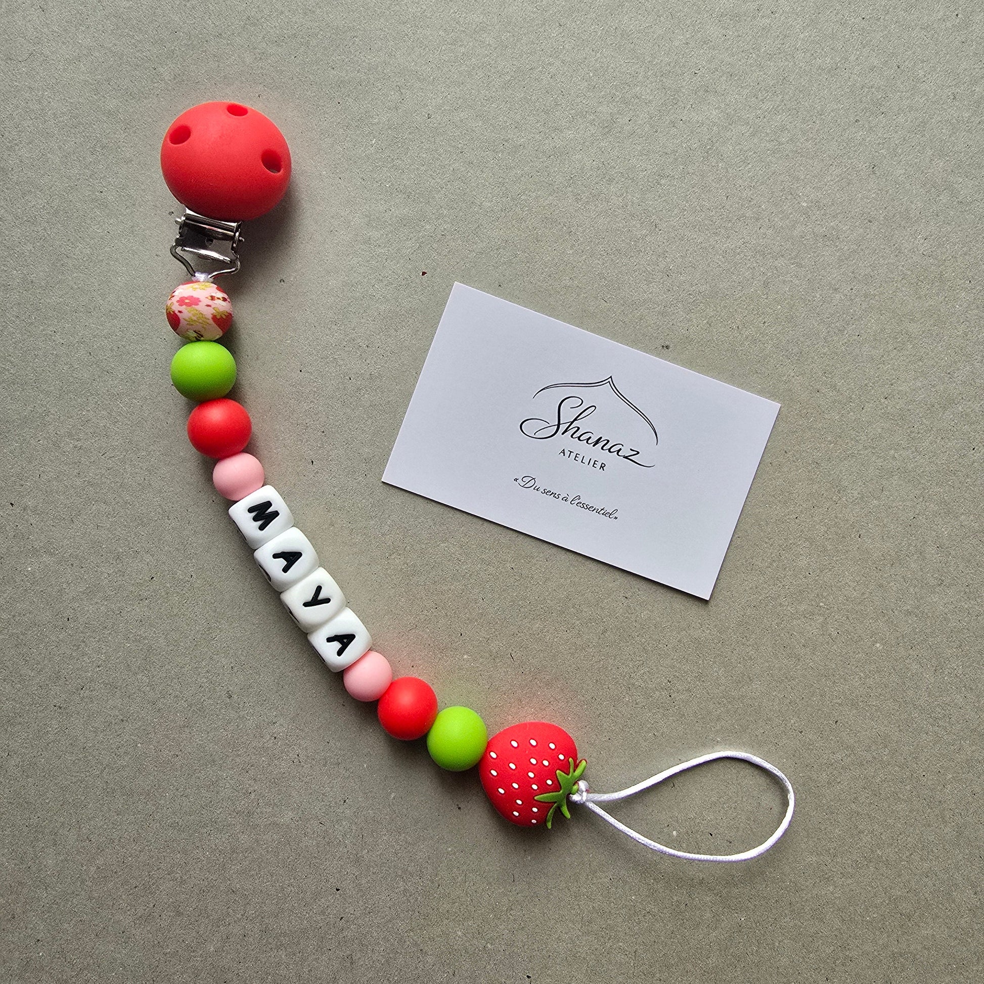Attache-tétine personnalisée prénom modèle Maya Fraise rouge et vert avec perle fraise