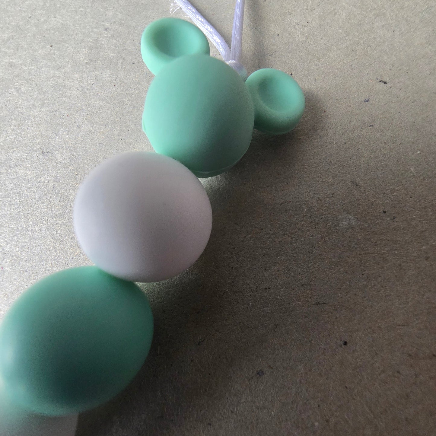 Détail des perles silicone et motif souris d’une attache-tétine personnalisée Adam Souris Menthe douce